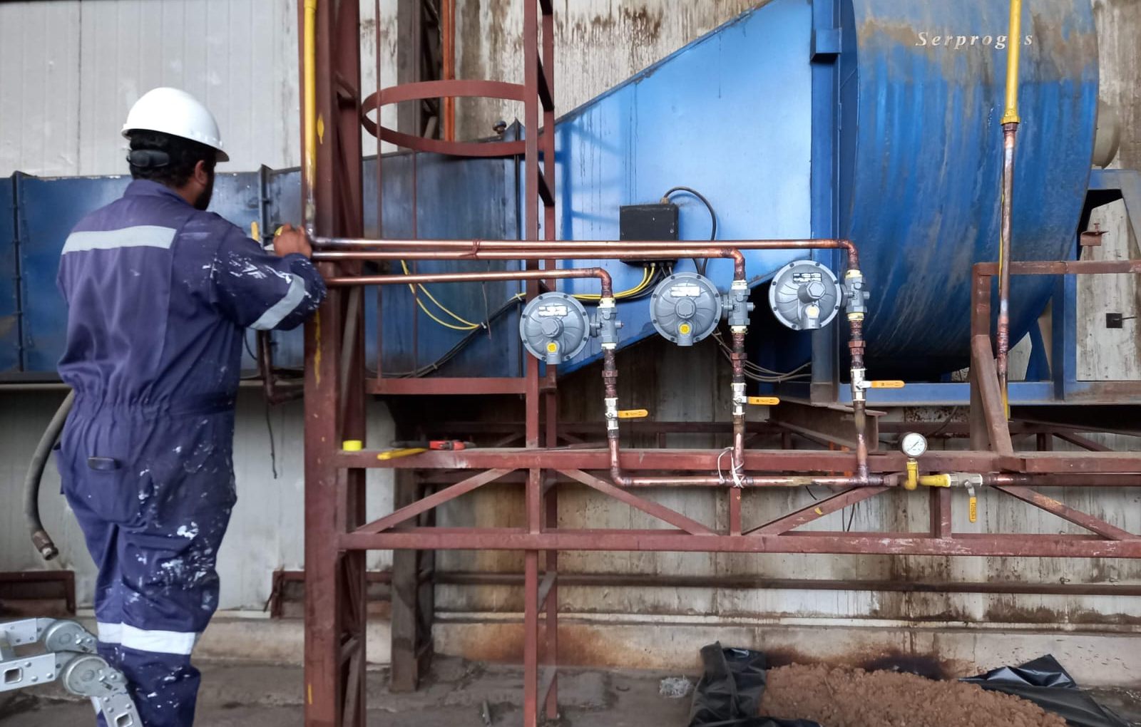 Técnico ajustando reguladores de gas en una línea industrial