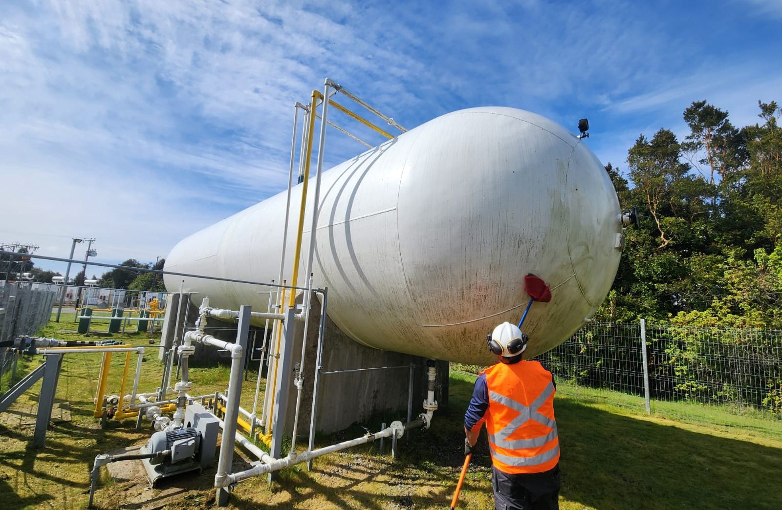 Técnico revisando un estanque de gas en una planta de abastecimiento